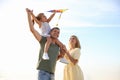 Happy parents with their child playing with kite on beach. Spending time in nature Royalty Free Stock Photo