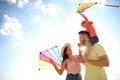 Happy parents and their child playing with kites on sunny day. Spending time in nature Royalty Free Stock Photo