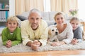 Happy parents with their children and puppy on floor Royalty Free Stock Photo