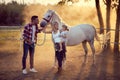 Happy parents with their daughter on the horse ranch.Young happy family having fun at countryside outdoors. Sunset, golden hour Royalty Free Stock Photo