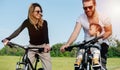 Happy parents and their grumpy baby son traveling on bikes in the countryside.