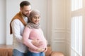 Muslim Couple Waiting For A Baby, Embracing Standing At Home
