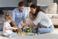 Happy parents with two little daughters playing with toys Royalty Free Stock Photo