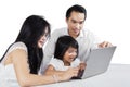 Happy parents using laptop with their child Royalty Free Stock Photo