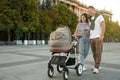 Happy parents walking with their baby in stroller Royalty Free Stock Photo