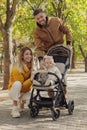 Happy parents walking with their baby in stroller at park on sunny day Royalty Free Stock Photo