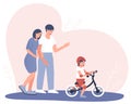 Happy parents watch how a child learns to ride a balance bike