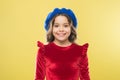 Happy parisian girl in french beret hat and elegant red dress on yellow background, kid retro fashion