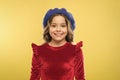 happy parisian girl in french beret hat and elegant red dress on yellow background, kid retro fashion