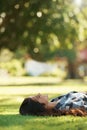 Happy, park and woman on grass to relax for rest in garden, nature or field with smile or peace. Smile, freedom and Royalty Free Stock Photo