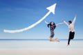 Happy partners jump under increase arrow sign cloud at beach