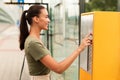 Happy Passenger Woman Buying Tram Tickets Via Vending Machine Outdoors