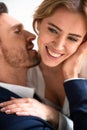 Happy passionate couple in love touching, kissing and huging. Focus on female happy eyes and hand in foreground