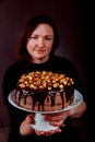 Happy pastry chef showing her homemade cake in her hand Royalty Free Stock Photo