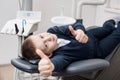 Happy patient boy showing thumbs up at dental office. Medicine, stomatology and health care concept Royalty Free Stock Photo