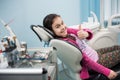 Happy patient girl showing thumbs up at dental clinic office. Medicine, stomatology and health care concept Royalty Free Stock Photo