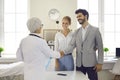 Happy young couple shaking hands with their family doctor or pregnancy specialist Royalty Free Stock Photo