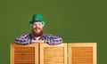 Happy Patrick`s Day. Funny fat bearded man in a green hat is laughing on a green background.