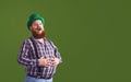 Happy Patrick`s Day. Funny fat bearded man in a green hat is laughing on a green background.