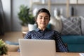 Happy peaceful millennial indian girl leaning on chair, resting.