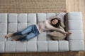 Happy peaceful young woman relaxing on comfortable couch at home