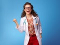 Happy pediatrician woman rejoicing on blue