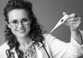 Happy pediatrician woman showing thermometer on