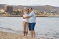 Happy pensioner woman and her husband taking romantic walk taking selfie - happy retired mature couple walking on the beach during