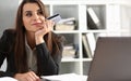 Happy pensive office worker holding bank credit card