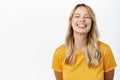Happy people. Beautiful girl smiling and showing white perfect teeth, laughing carefree, standing in yellow tshirt over