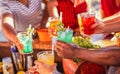 Happy people cheering with mojito and having fun - Multiracial friends drinking coktails in a beach bar outside in summer days Royalty Free Stock Photo