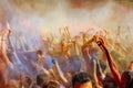 Happy people crowd partying under colorful powder cloud at holi