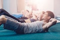 Happy people doing an exercise on a crunches lying