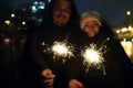 Happy people enjoying fireworks outdoors. Couple with sparklers at night Royalty Free Stock Photo