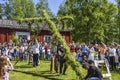 Happy people enjoying to watch pole standing moment effort by swedish people and waiting for the swedish mid summer day