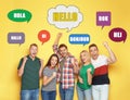 Happy people and illustration of speech bubbles with word Hello written in different languages on yellow background Royalty Free Stock Photo