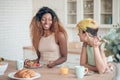 Laughing dark-skinned woman and girlfriend during breakfast