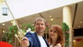 Happy people make selfies. Lovely woman enjoying shopping at the mall with her boyfriend Royalty Free Stock Photo