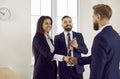 Happy people meeting in the office, making a business deal and exchanging handshakes Royalty Free Stock Photo