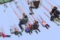 Happy people play chairoplane in an amusement park