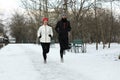 Happy people running in winter park. Outdoors sports exercises Royalty Free Stock Photo