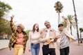 Happy people singing and dancing outdoors. Group of friends having fun in a day party playing the ukulele. Royalty Free Stock Photo