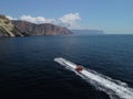 Happy people swim on air mattress behind a high speed water bike. Tourists ride on inflatable watercraft boat. Sea