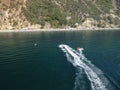 Happy people swim on air mattress behind a high speed water bike. Tourists ride on inflatable watercraft boat. Sea