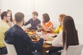 Group of happy young people talking at dinner table, friends party Royalty Free Stock Photo