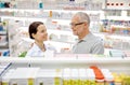 Happy pharmacist talking to senior man at pharmacy