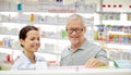 Happy pharmacist talking to senior man at pharmacy