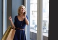 Happy, phone call and woman with shopping bags by window for communication in mall or boutique. Smile, cellphone and Royalty Free Stock Photo