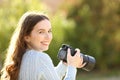 Happy photographer in a park looks at you