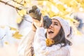 Happy photographer in a winter cap photoshoots outdoors in colorful fall nature